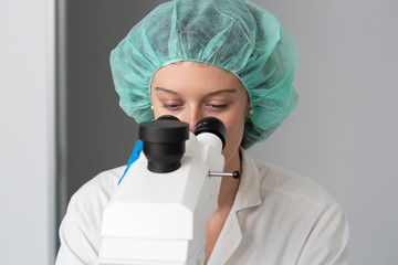 Biologist observing samples at microscope