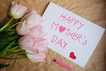  Bouquet of pink tulips and gift card on brown crumpled paper background, Happy mother's day and valentine day