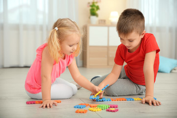 Canvas Print - Cute little children playing with pazzles at home