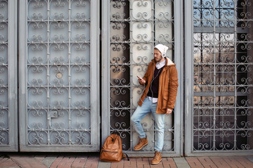 Wall Mural - Handsome hipster with headphones listening to music outdoors