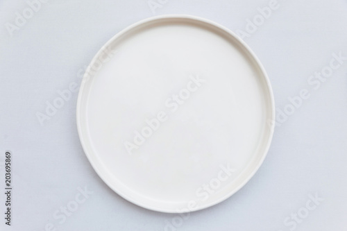 Cuadros en Lienzo Top view of white empty plate on white tablecloth.