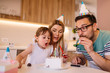 © Nebojsa - Young girl blows candles on birthday cake while she is celebrating a birthday with family