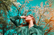 © Subbotina Anna - Beauty fashion model girl posing over blooming trees, enjoying nature in spring apple orchard. Beautiful brunette young woman over sky in Garden with blooming apple trees. blossom flowers outdoors