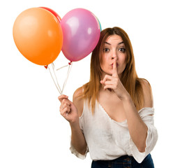 Wall Mural - Beautiful young girl holding a balloon and making silence gesture