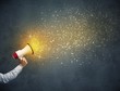 © ra2 studio - Caucasian business hand holding megaphone with yellow sparkles