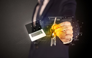 Businessman in suit holding keys with statistics, graphs and icons around
