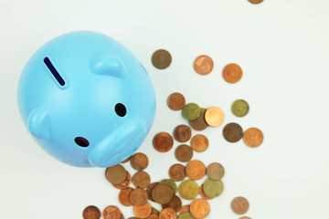 Wall Mural - Blue piggy bank standing on coins, money savings concept..