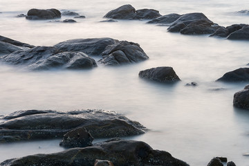 Water in the sea with long explosure at the rocks.