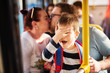 © dusanpetkovic1 - Young happy couple is showing affection through a kiss in a bus while their young adorable little toddler is facepalming because of second hand shame.