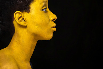 Wall Mural - Cheerful young african woman with art fashion makeup. An amazing woman with black and yellow paint makeup