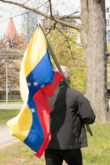 senior man with Venezuelan flag in park looking for peace and showing support for Venezuela