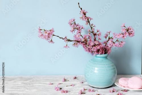 Fotografía still life with bouquet of blooming cherry branches or sakura in a vase with mac