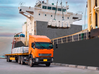 Sugar bags are loading in hold of bulk-vessel at industrial port,Pick up sugar bags from truck to  loading on board.