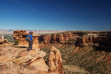 Hiker Is Sitting On The Cliff In Colorado National Monument, USA