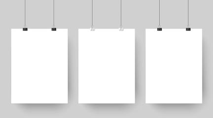 Wall Mural - Empty affiche mockup hanging on paper clips. White blank advertising poster template casts shadow on gray background vector illustration