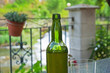 Vaso de cristal y botella de  Sidra ( jugo fermentado de la manzana ).  En terraza de bar al aire libre y fondo desenfocado