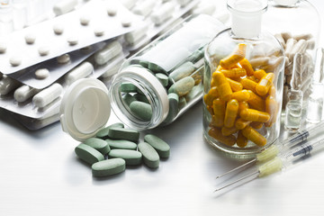 Wall Mural - Medicines in tablets, capsules and injections on a metal table as a symbol of the pharmaceutical industry