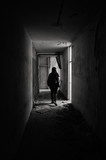 Fototapeta Na drzwi - Silhouette of a woman in an abandoned devastated hotel