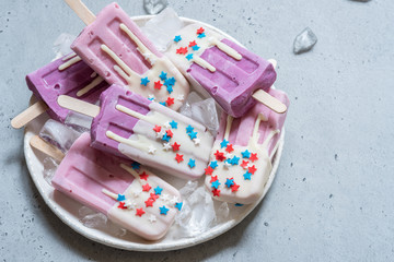 Wall Mural - Yogurt popsicles topped with white chocolate and american stars sprinkles