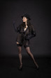 © lik13vvs - Beautiful young girl dancing in black tunic, black gloves and black hat.