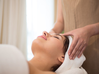 Masseur doing massage the head of an woman in the spa salon