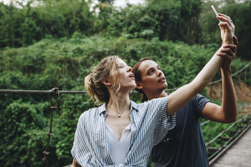 Wall Mural - Caucasian woman and man taking a selfie outdoors recreational leisure, freedom and adventure concept