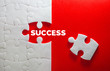 © Cozine - Close up piece of white jigsaw puzzle with SUCCESS text , a concept of business challenge success completion with teamwork