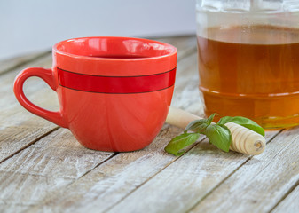 Red cup of tea, basil leaf and honey