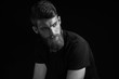 © USM Photography - Black and white portrait of young bearded man isolated at black background Guy with beard thoughtful, pensive, charming, looking forward Trendy hipster think of problem solving, finding solution