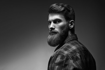 Black and white photo of bearded stylish businessman Handsome confident perfect hairstyle man indoor .