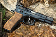 black 9mm pistol on a background of stones and moss