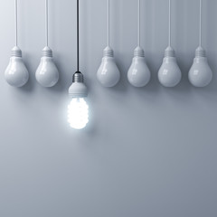 Leinwandbilder - One hanging eco energy saving light bulb glowing and standing out from unlit incandescent bulbs on white wall background with shadow , leadership and different creative idea concepts . 3D rendering.