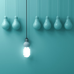 Fototapete - One hanging eco energy saving light bulb glowing and standing out from unlit incandescent bulbs on green pastel wall background , leadership and different creative idea concepts . 3D rendering.