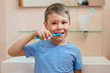 © shangarey - Happy kid or child brushing teeth in bathroom. Dental hygiene.