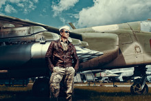 Fighter Pilot With Sunglasses In Full Flight Gear Standing At The Front Of His Jet