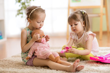 Children Playing Doctor With Doll In Playschool