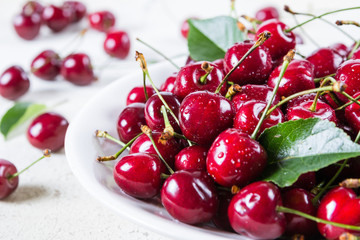 Fresh red ripe cherries on white plate