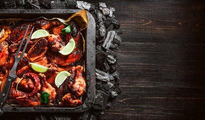 Wall Mural - chicken wings of barbecue in honey sauce with lime slices. the dish is made and served in a rustic style