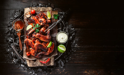 Wall Mural - chicken wings of barbecue in honey sauce with lime slices. the dish is made and served in a rustic style