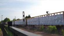 Cargo Train Passing Through Town In Fence
