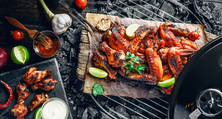 Wall Mural - chicken wings of barbecue in honey sauce with lime slices. the dish is made and served in a rustic style