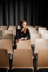 young pretty woman sitting in co-working office, conference room. Woman waiting for conference. Empty office room. One busines lady.