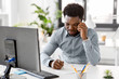 © Syda Productions - business, people, communication and technology concept - african american businessman with papers and computer calling on smartphone at office