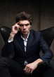 © Bakulov - Business portrait of a serious young man sitting in a chair.
