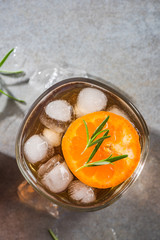 Wall Mural - Glass with ice cold tea beverage and rosemary garnish