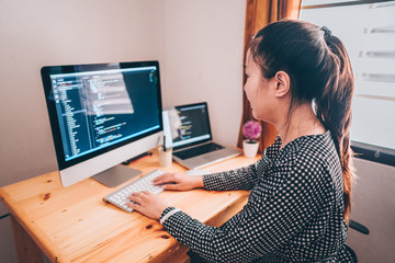 Wall Mural - beautyful programmer women working at home with laptop and computer pc. woman writing, coding for cr
