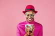 © Carlos David - Portrait of young woman in red hat against pink background
