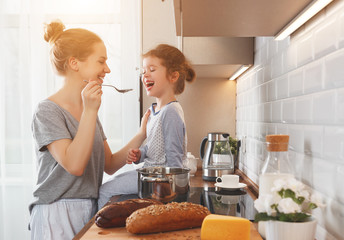 Wall Mural - preparation of family breakfast. mother and child daughter cook porridge in morning