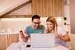 © Nebojsa - Happy couple doing online shopping with credit card and laptop
