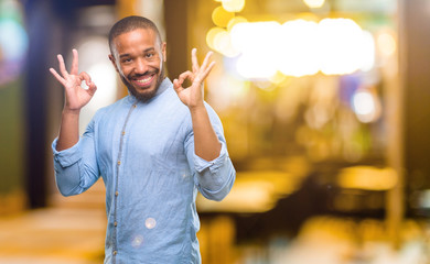 Poster - African american man with beard doing ok sign gesture with both hands expressing meditation and relaxation at night